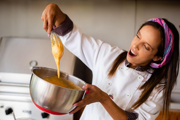 Image by jramaraljr from Pixabay.&nbsp;A woman chef joyfully preparing food.&nbsp;